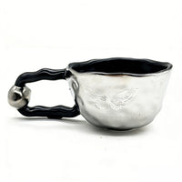 Ceramic cup with butterfly design and irregular rim 1