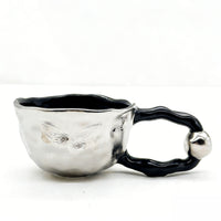 Ceramic cup with butterfly design and irregular rim 2