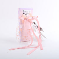 Glass cup gift with pink ribbon bows and silver hair bow clips in front view