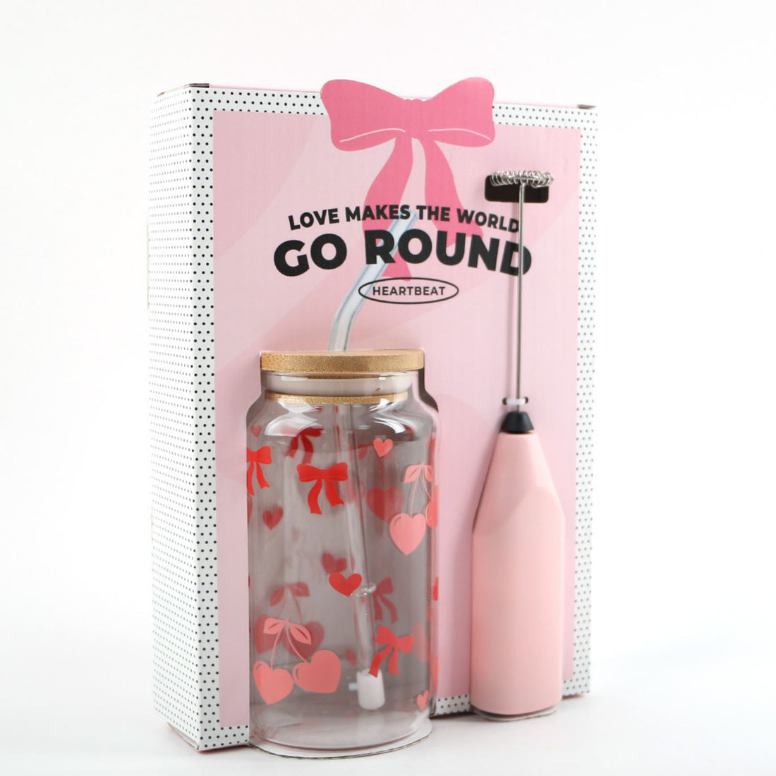 Pink electric frother bottle with straw lid and glass tumbler with red heart pattern