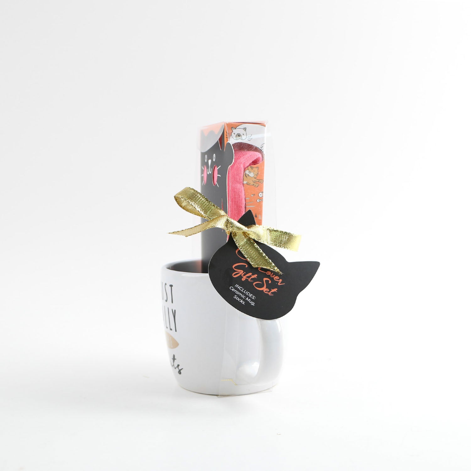White ceramic mug with cat-shaped gift tag, paper box shows pink socks, gold ribbon