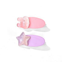 Two pastel hair clips: pink bunny-ear style and lavender star-shaped clip