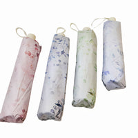 Set of four folding umbrellas in pastel pink, blue, green, and white floral prints