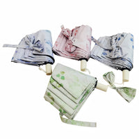 Assorted folding umbrellas in stacked bundles with blue, pink, green, and white floral prints