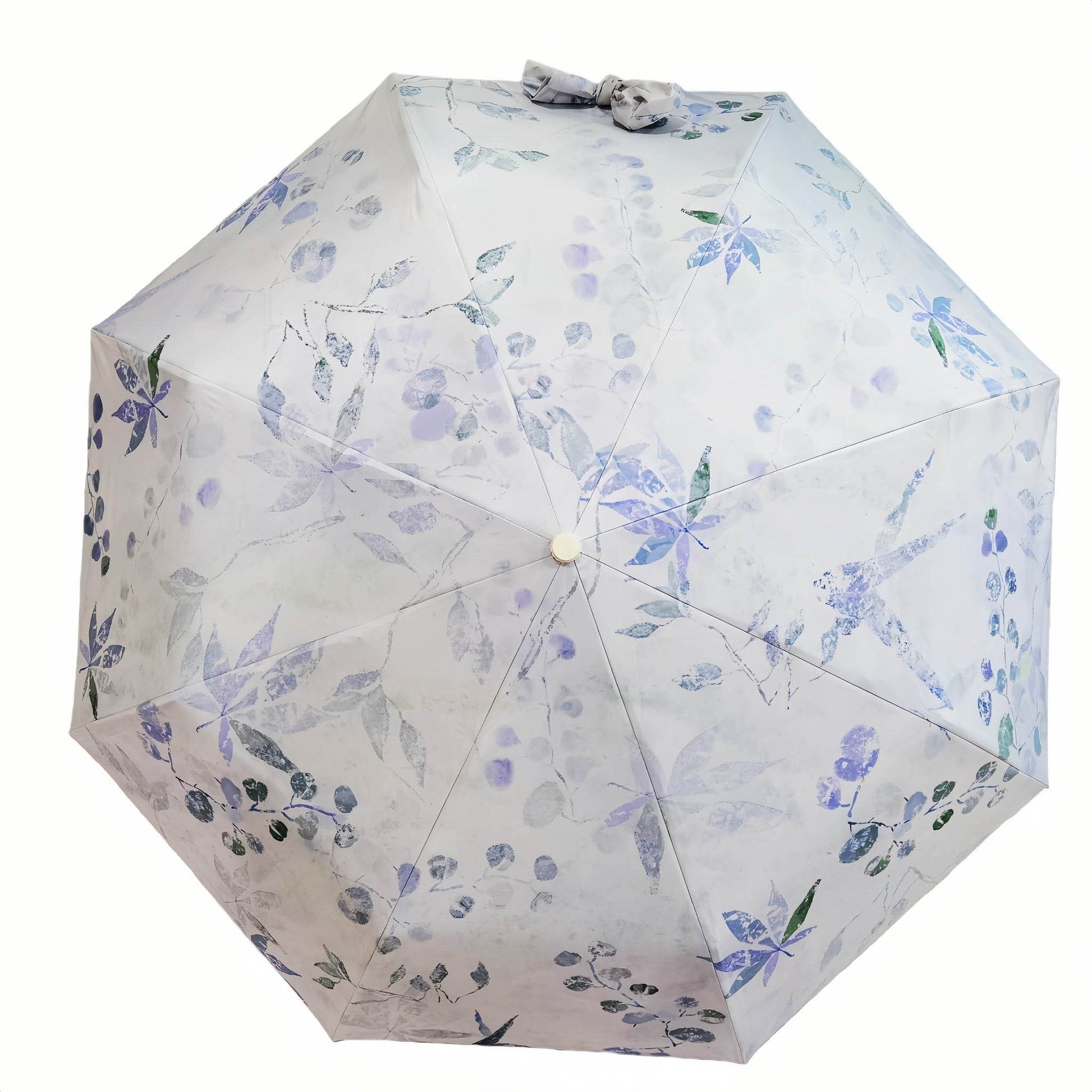 Folding umbrella with white fabric and blue floral pattern, open canopy with center button