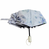 Blue floral folding umbrella, open canopy with black pole and beige handle cap