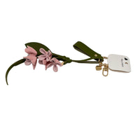 Green leaf and pink flower keychain with gold clasp and keyring on label tag.