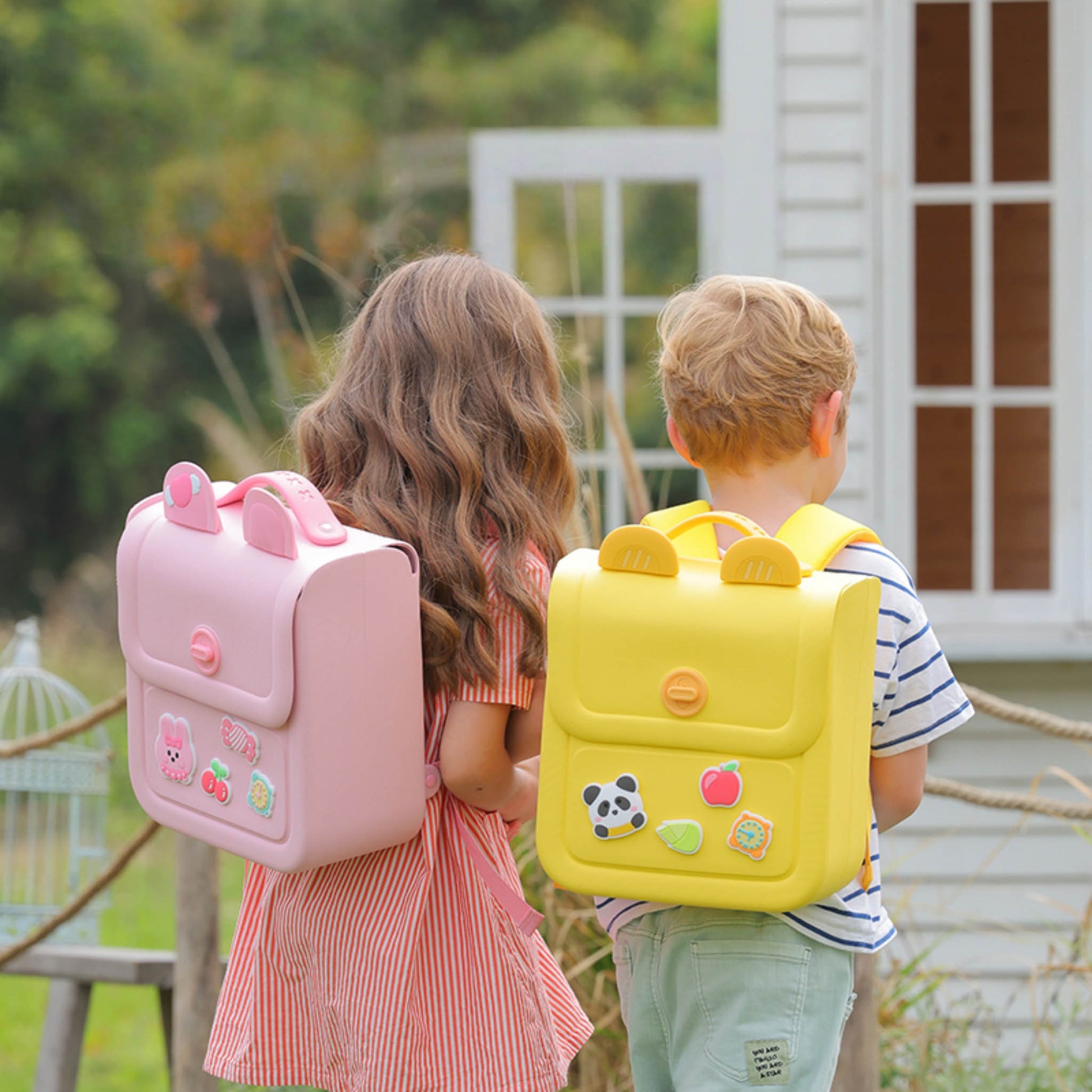 Pink and yellow silicone kids backpacks with front flap pockets, worn by children