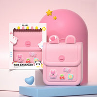 Pink silicone kids backpack with front flap pocket, cartoon charm patches, and handle