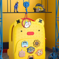 Yellow silicone backpack with red zipper and hanging loop, featuring cartoon animal badges