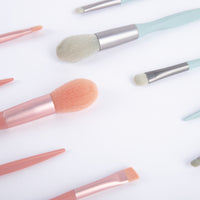 Makeup brush set close-up with peach bristle brush and mint-handled brushes