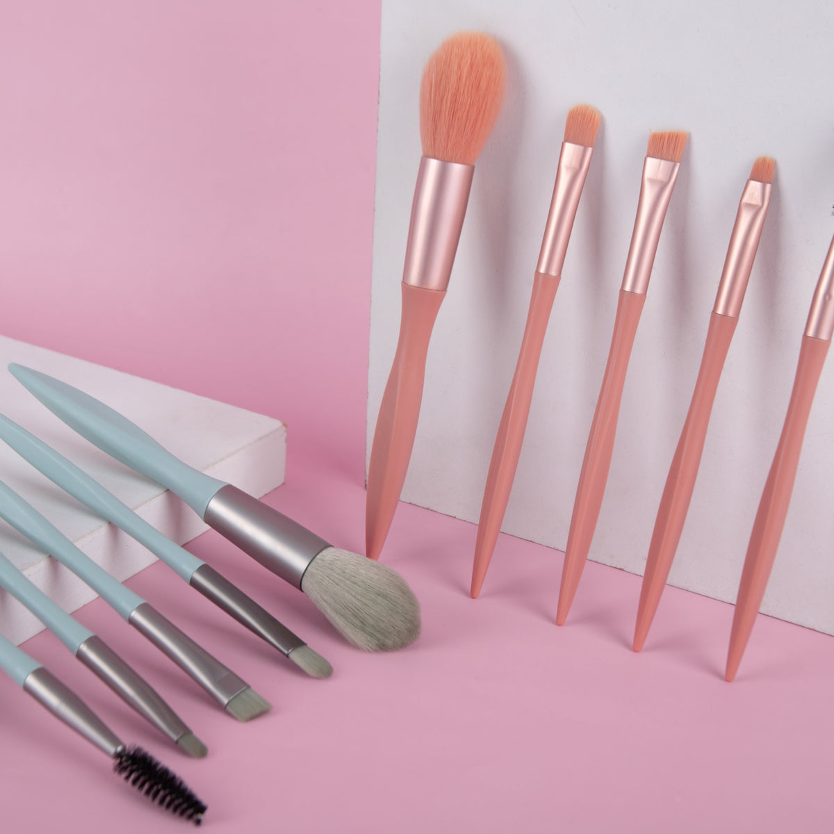 Makeup brush set with rose-gold handles, peach bristles, and mint-handled brushes