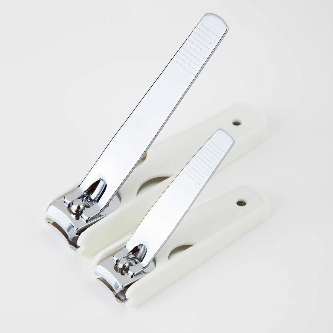 Metal nail clipper pair with chrome blades and off-white handles