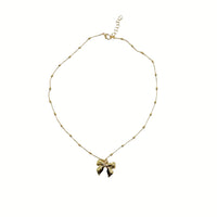 Gold beaded necklace with bow charm pendant at center
