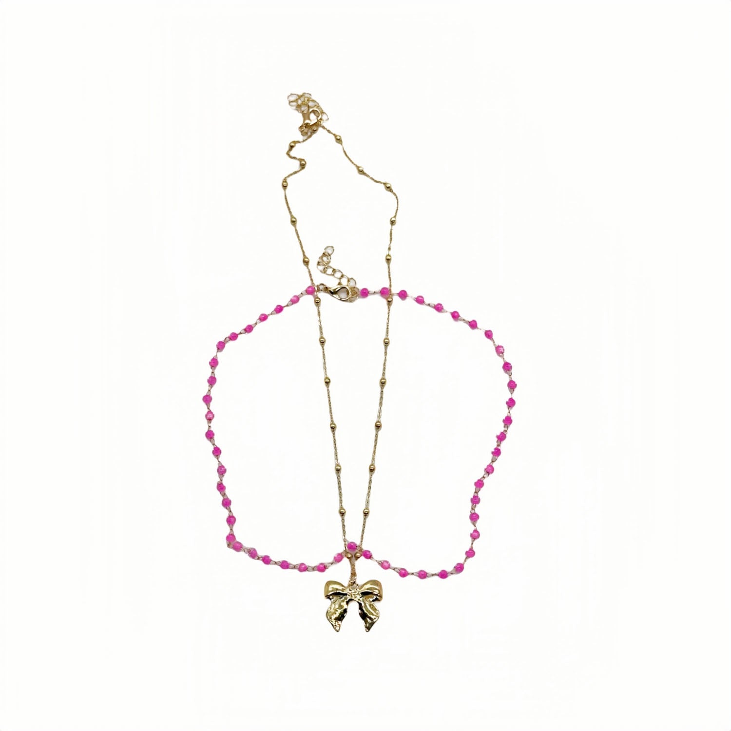 Gold necklace with pink beaded loop and bow charm pendant
