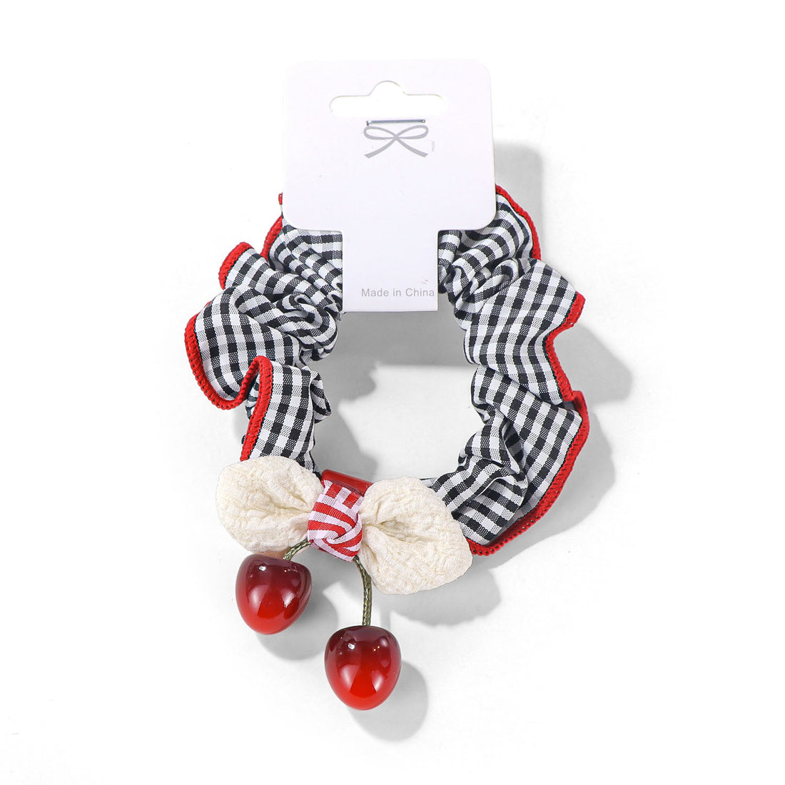 Gingham fabric hair tie with red trim and three dangling red beads