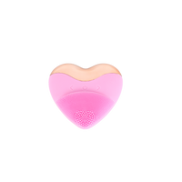 Pink heart-shaped facial cleansing brush with power and control buttons on top