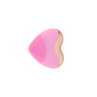 Heart-shaped electric facial cleansing brush with pink silicone bristle surface