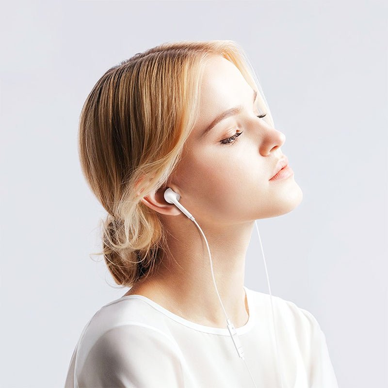 White Lightning earbuds worn in ear, cable running from headset