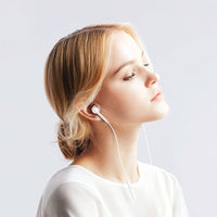 White Lightning earbuds worn in ear, cable running from headset