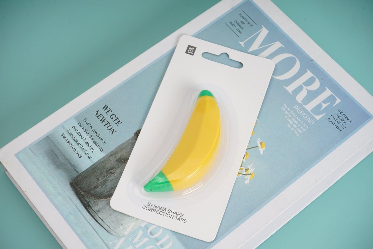 Banana-shaped correction tape blister pack with hanging tab, yellow tape and green end