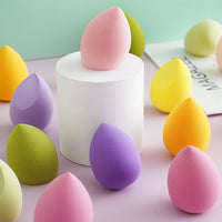 Set of pastel teardrop makeup sponge puffs on a white display block