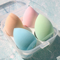 Pastel makeup sponge puffs in a clear bin: beige, pink, green, and blue