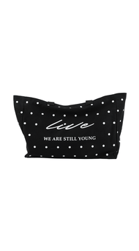 Black dot tote bag with wide top, white dots, and 'WE ARE STILL YOUNG' logo