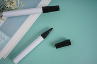 Black marker pens, white barrel with black cap