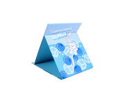 Foldable mirror, blue drink-themed cover propped open
