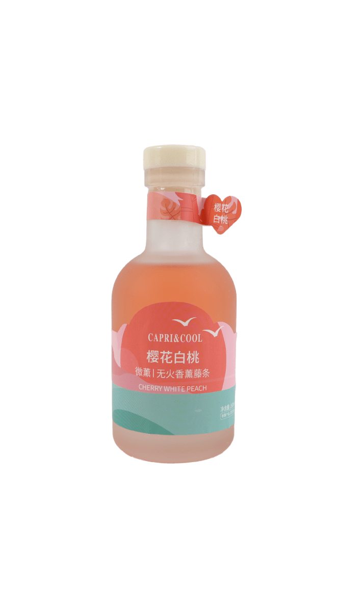 Reed diffuser bottle with cherry-peach label and white cap, heart emblem