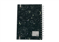 Celestial notebook back cover with spiral rings and star-chart symbols pattern.