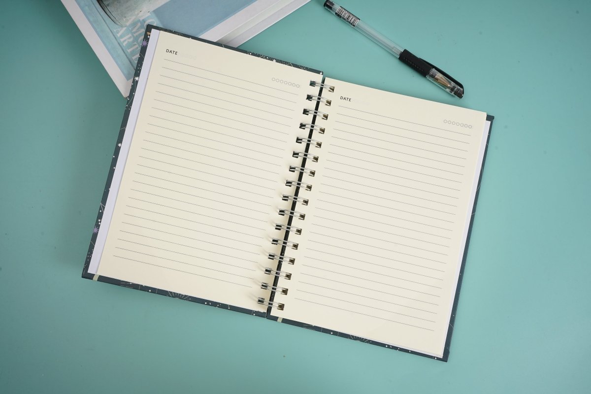 Open celestial notebook with ruled pages and metal spiral binding.