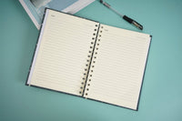 Open celestial notebook with ruled pages and metal spiral binding.