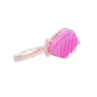 Plastic hair brush with shell-shaped bristles, bright pink head and clear handle.