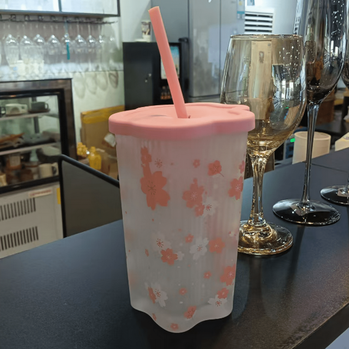 Pink cherry blossom tumbler with coral lid, straw, and all-over floral print