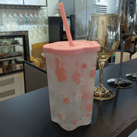 Pink cherry blossom tumbler with coral lid, straw, and all-over floral print