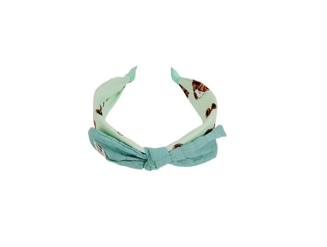 Mint green fabric headband with soft knotted bow and animal-print lining