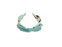 Mint green fabric headband with soft knotted bow and animal-print lining