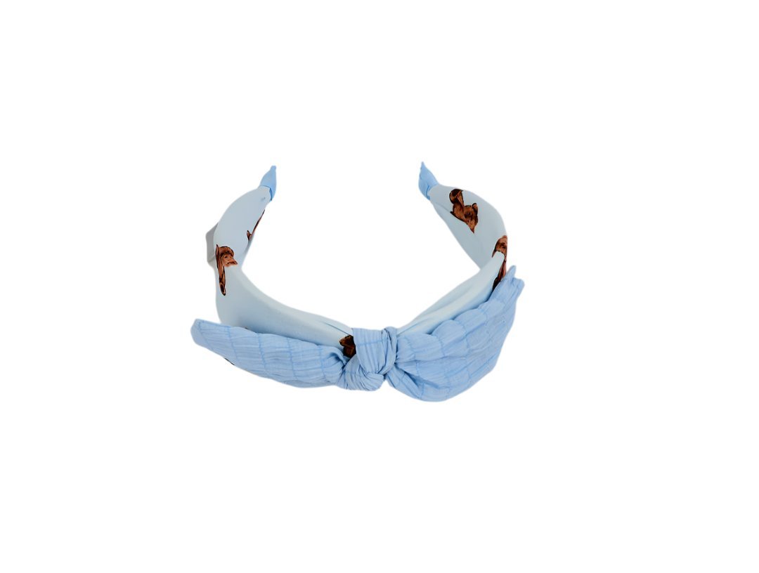 Light blue fabric headband with soft knotted bow and animal-print accents