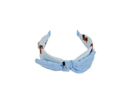 Light blue fabric headband with soft knotted bow and animal-print accents