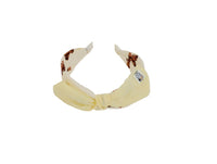 Off-white fabric headband with soft knotted bow and animal-print lining