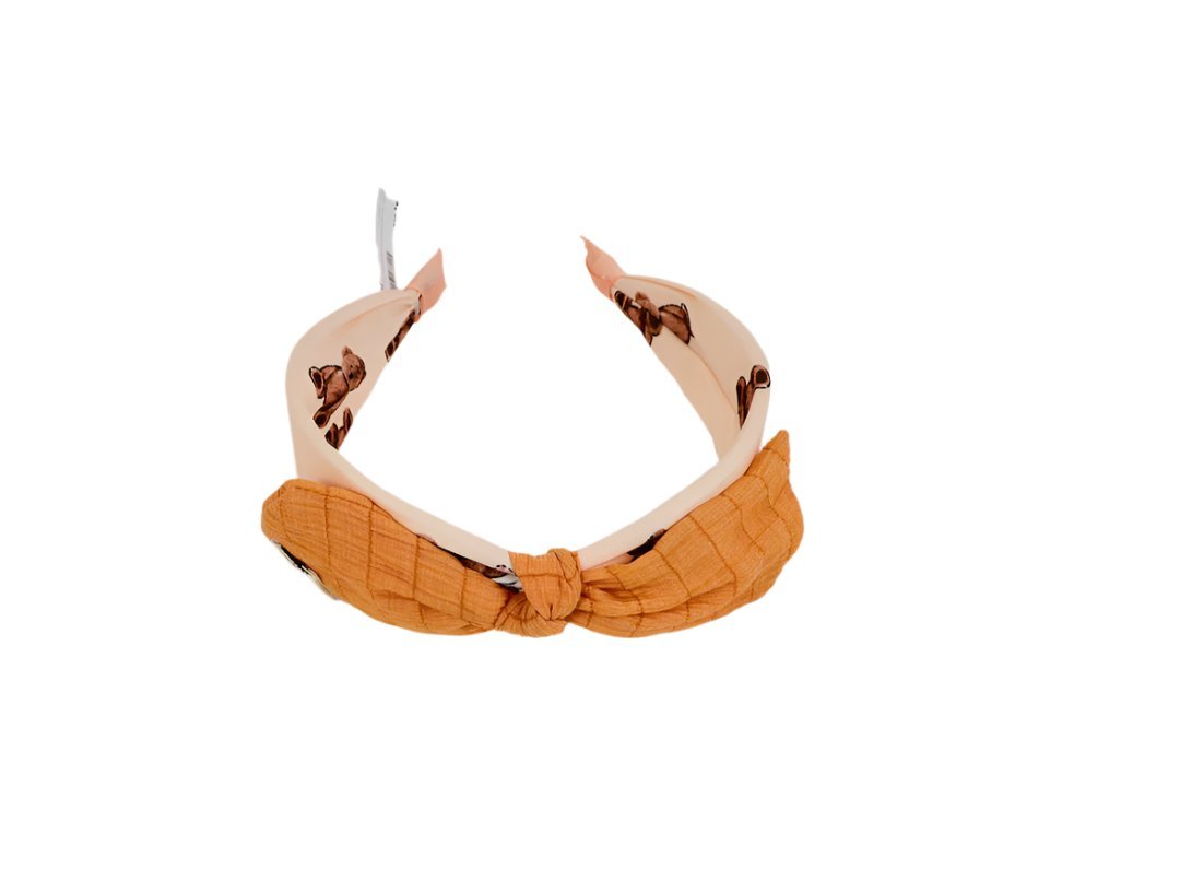 Orange fabric headband with soft knot and animal-print lining on the inner band