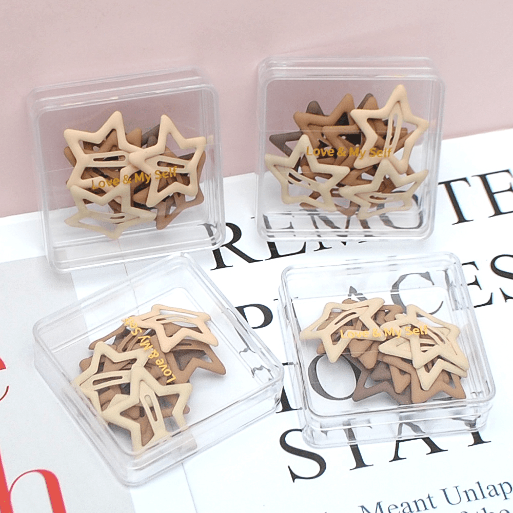 Star-shaped hair clips in neutral colors in clear organizer boxes, assorted mix.