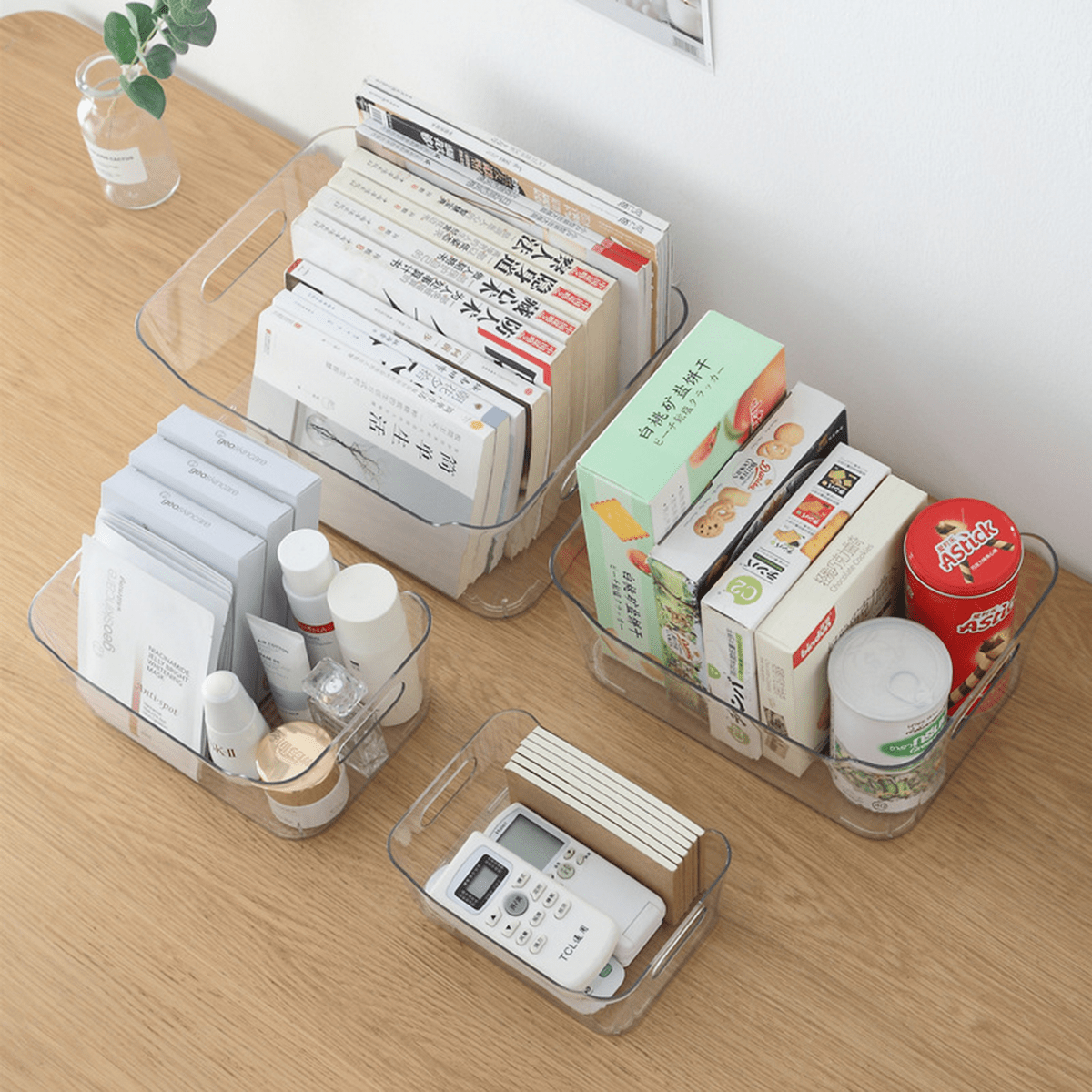 Clear plastic storage organizer tray holding books and small supplies on a table