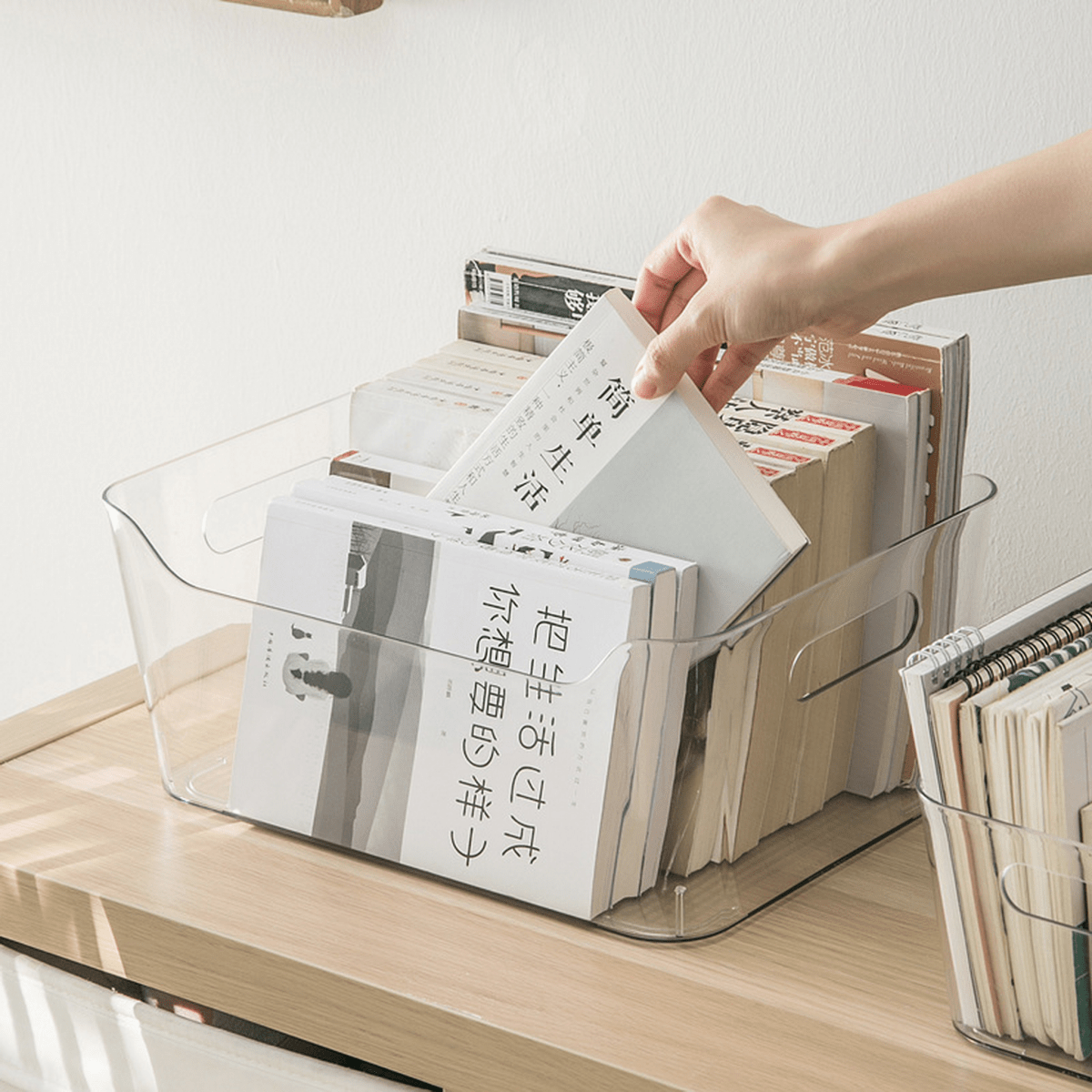 Clear plastic storage organizer bin with open front as hand places documents