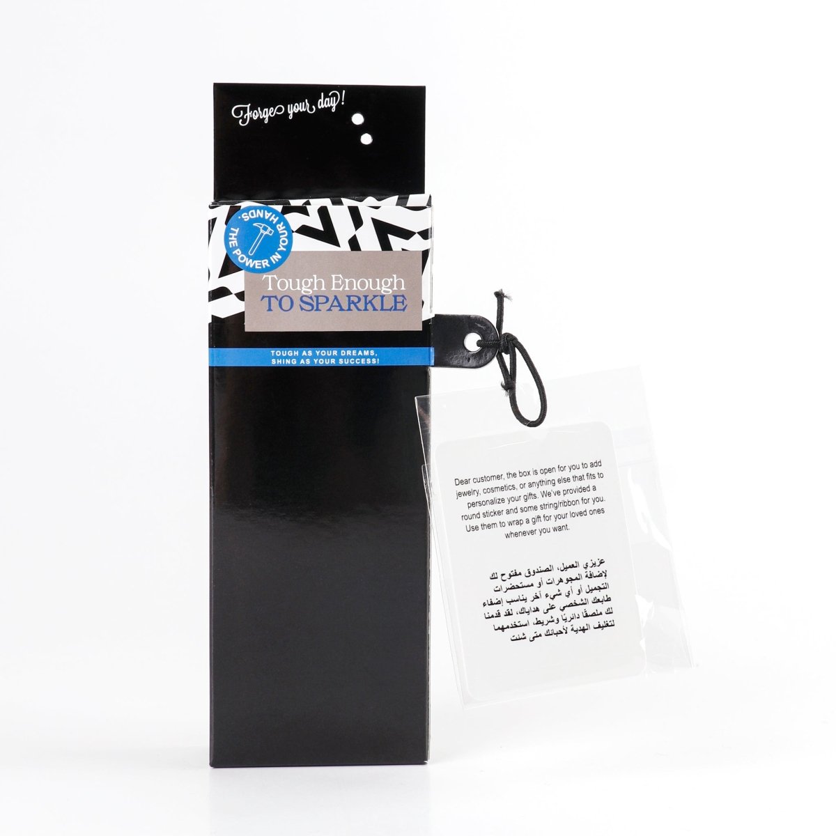 Black gift box with hanging tag and key ring; gray mug visible inside