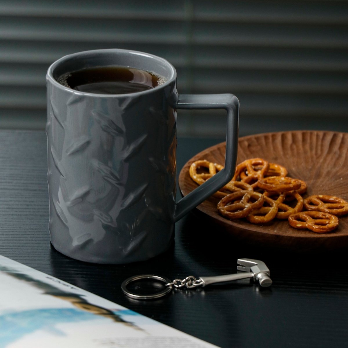 Gray ceramic mug with handle, filled coffee; includes small key ring and charm