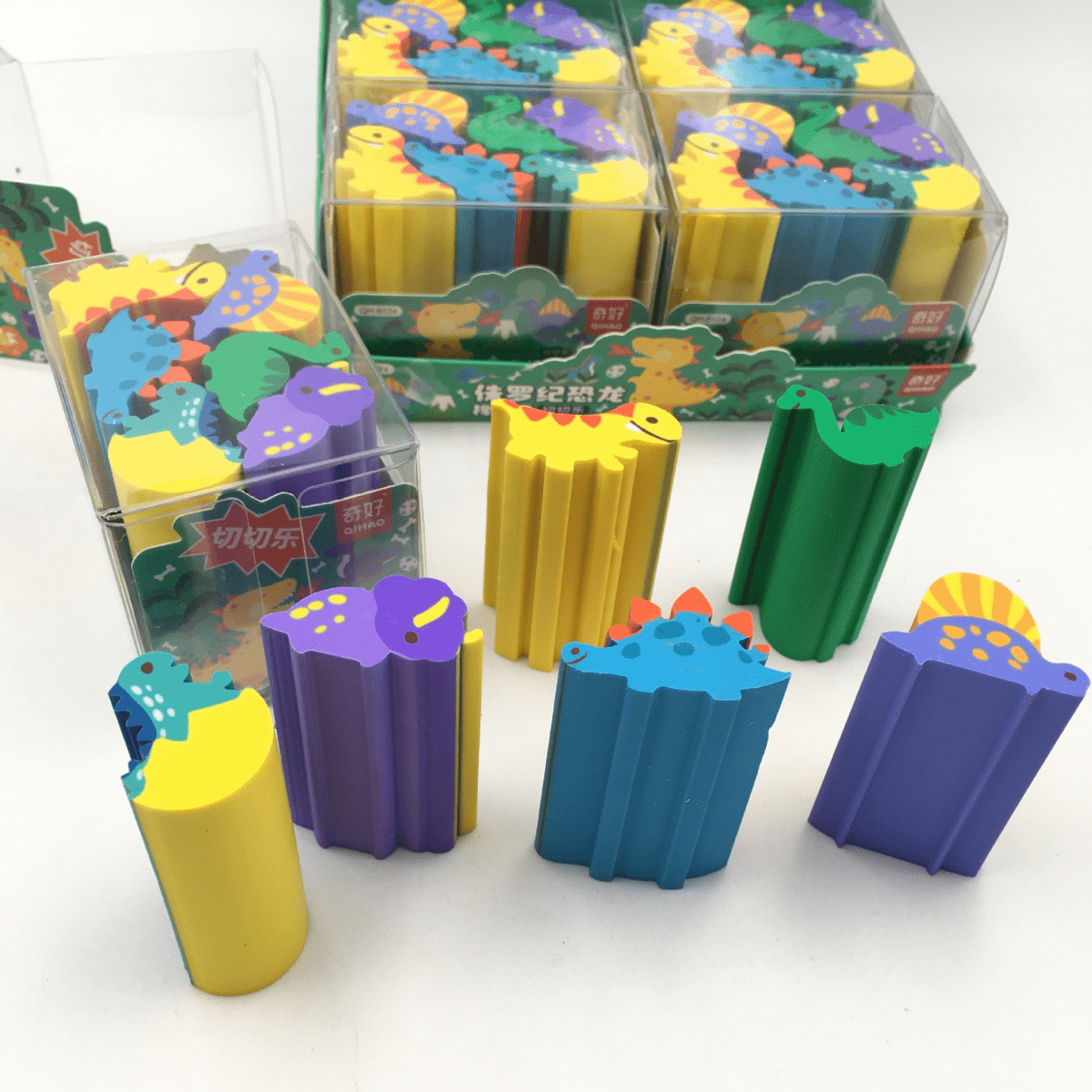 Dinosaur erasers in clear tray, including blue, purple, green, yellow, and orange styles