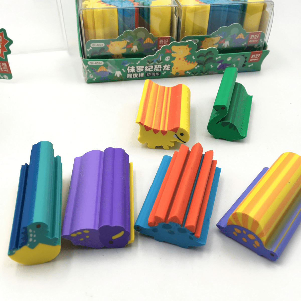 Colorful dinosaur erasers arranged in rows, with orange, green, purple, blue, and yellow pieces
